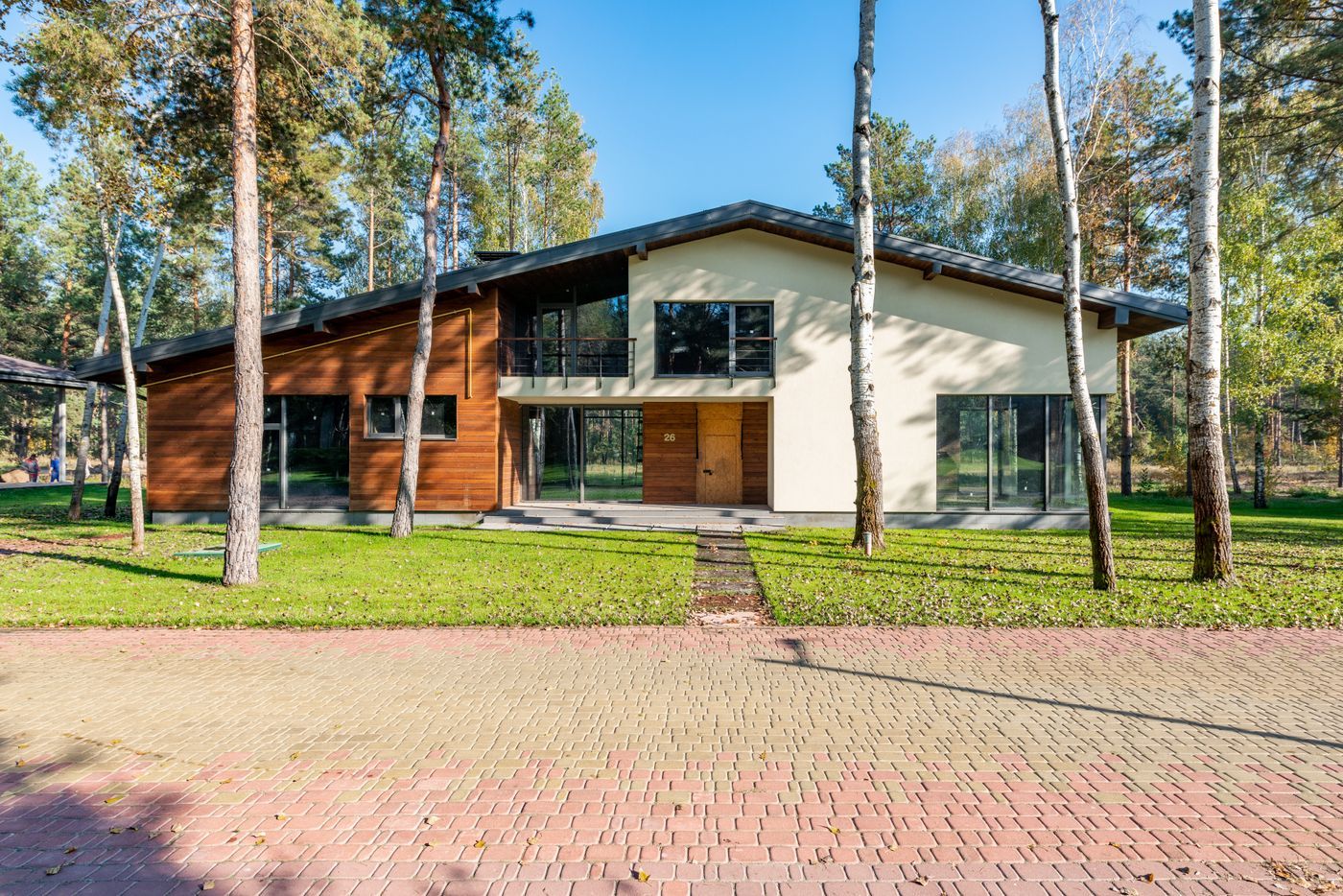 Woning met strak gazon, berken en sierbestrating